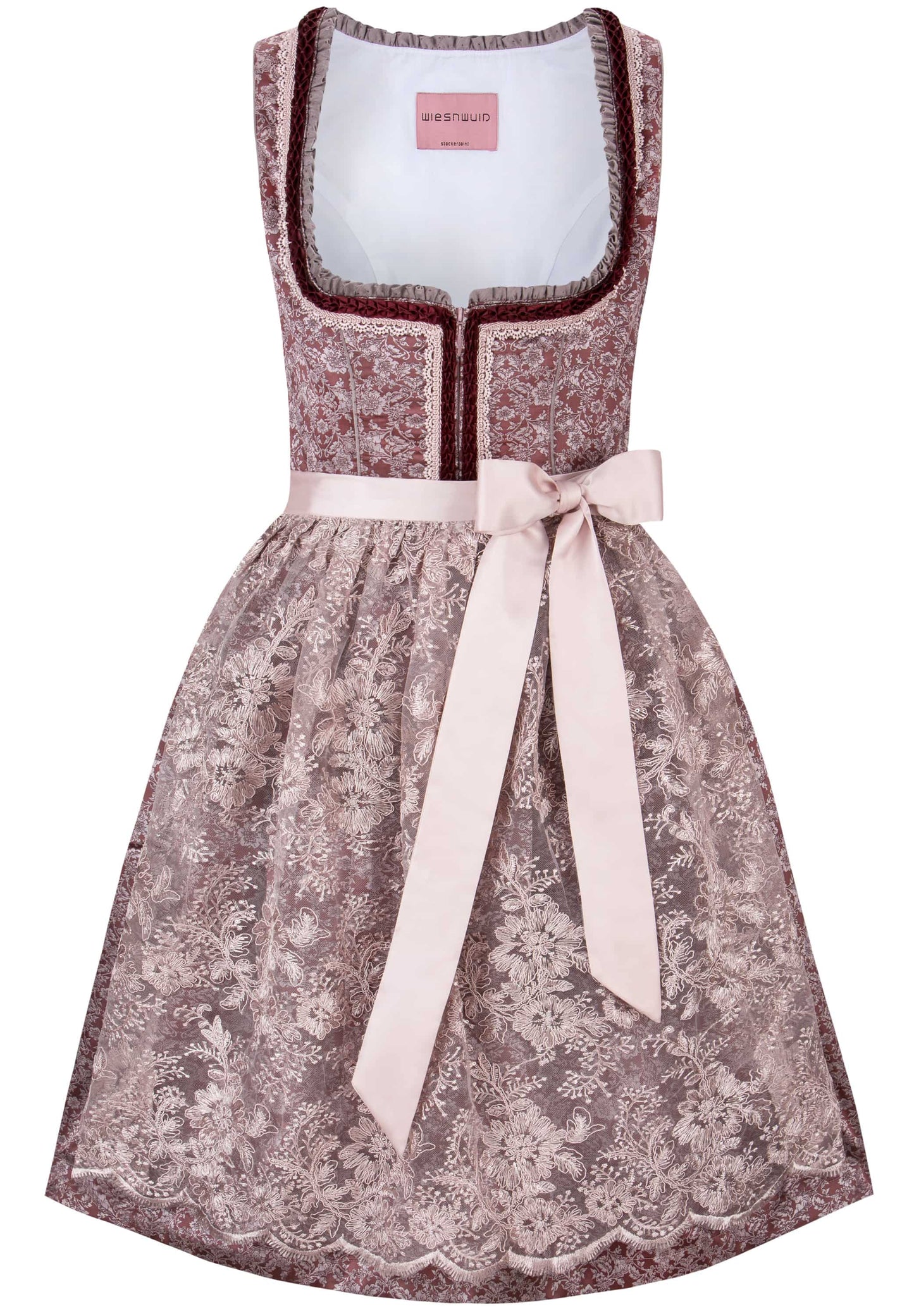 A sleeveless dirndl dress with a dusty rose floral lace pattern, a white inner lining, dark red trim, and a light pink satin waist tie bow, shown on a plain white background.