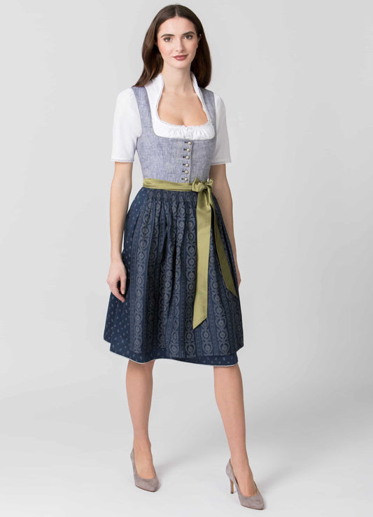 Woman wearing a traditional Bavarian dirndl in gray and blue with a lovely green apron string.