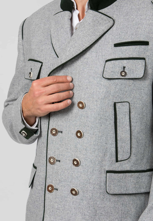 A close-up of a gray double-breasted blazer with black piping and brown buttons, worn by a model whose hand is resting on the lapel.