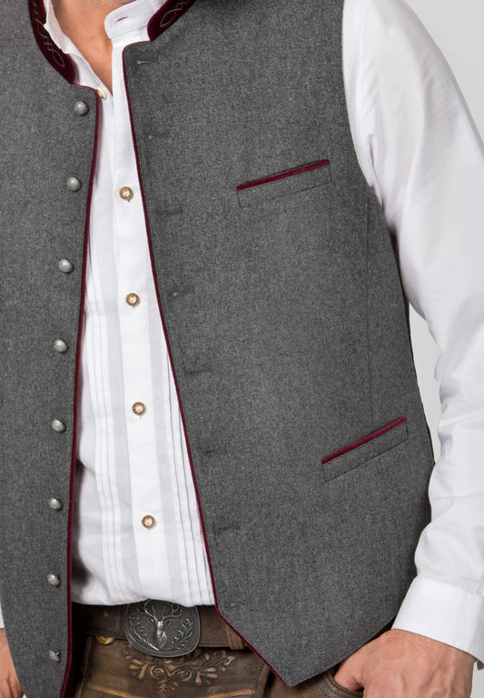 Gray vest with red trim worn over a white shirt, close-up view.