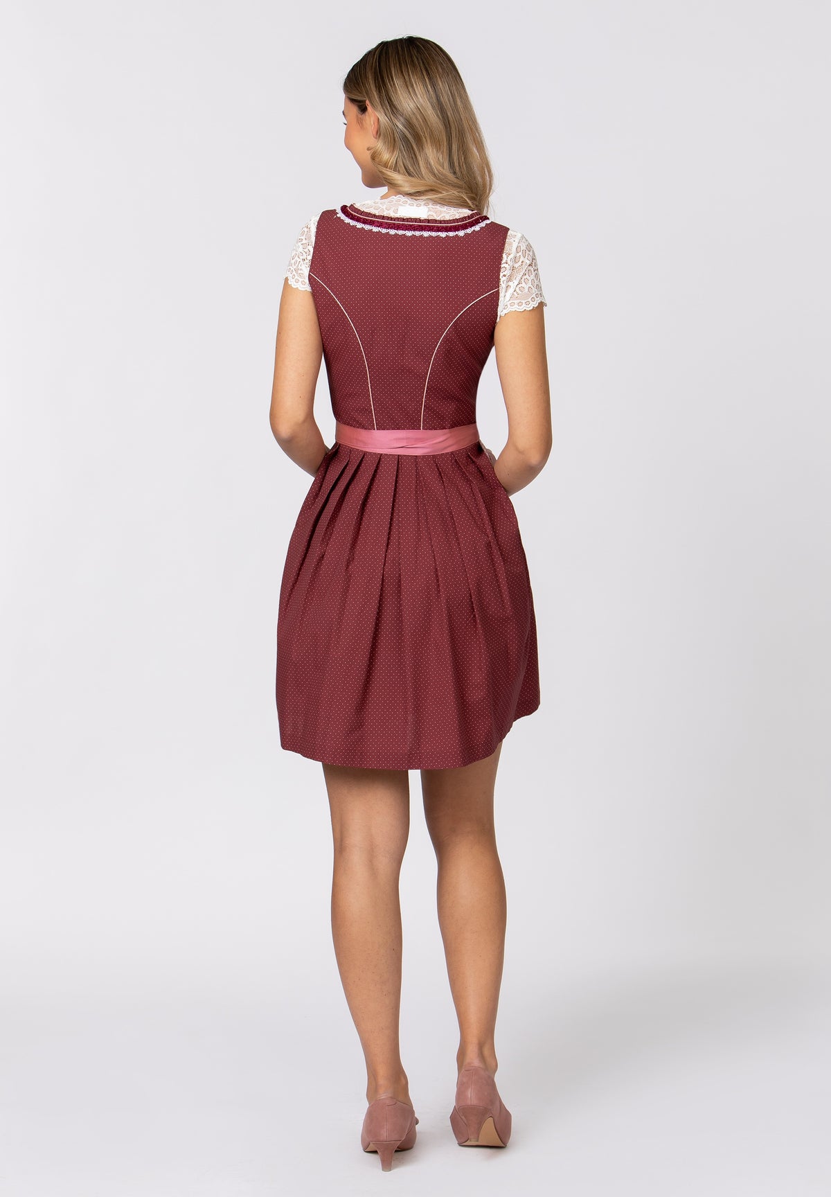 A woman wearing a Schwandorf Women's Midi Dirndl with a white and red checkered design, featuring ruffles at the neckline and a high-quality, color-coordinated apron with decorative trim.
