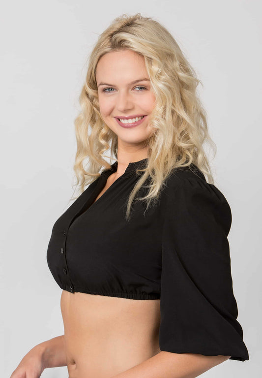 A smiling blonde woman wearing a black short-sleeve crop top with puff sleeves, photographed against a light gray studio background.