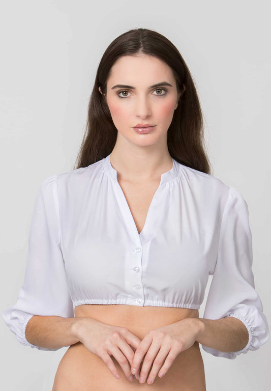 A woman modeling a white long-sleeve crop top blouse with a gathered neckline and button front, photographed against a plain light gray studio background.