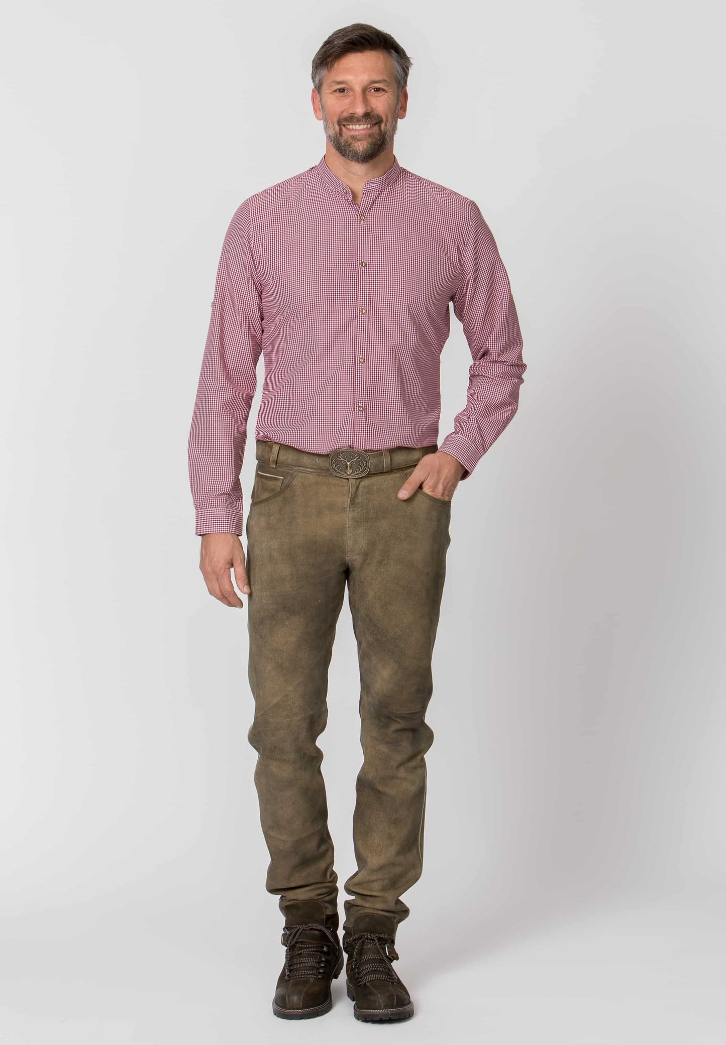 Man wearing a pink shirt and brown pants on a white background