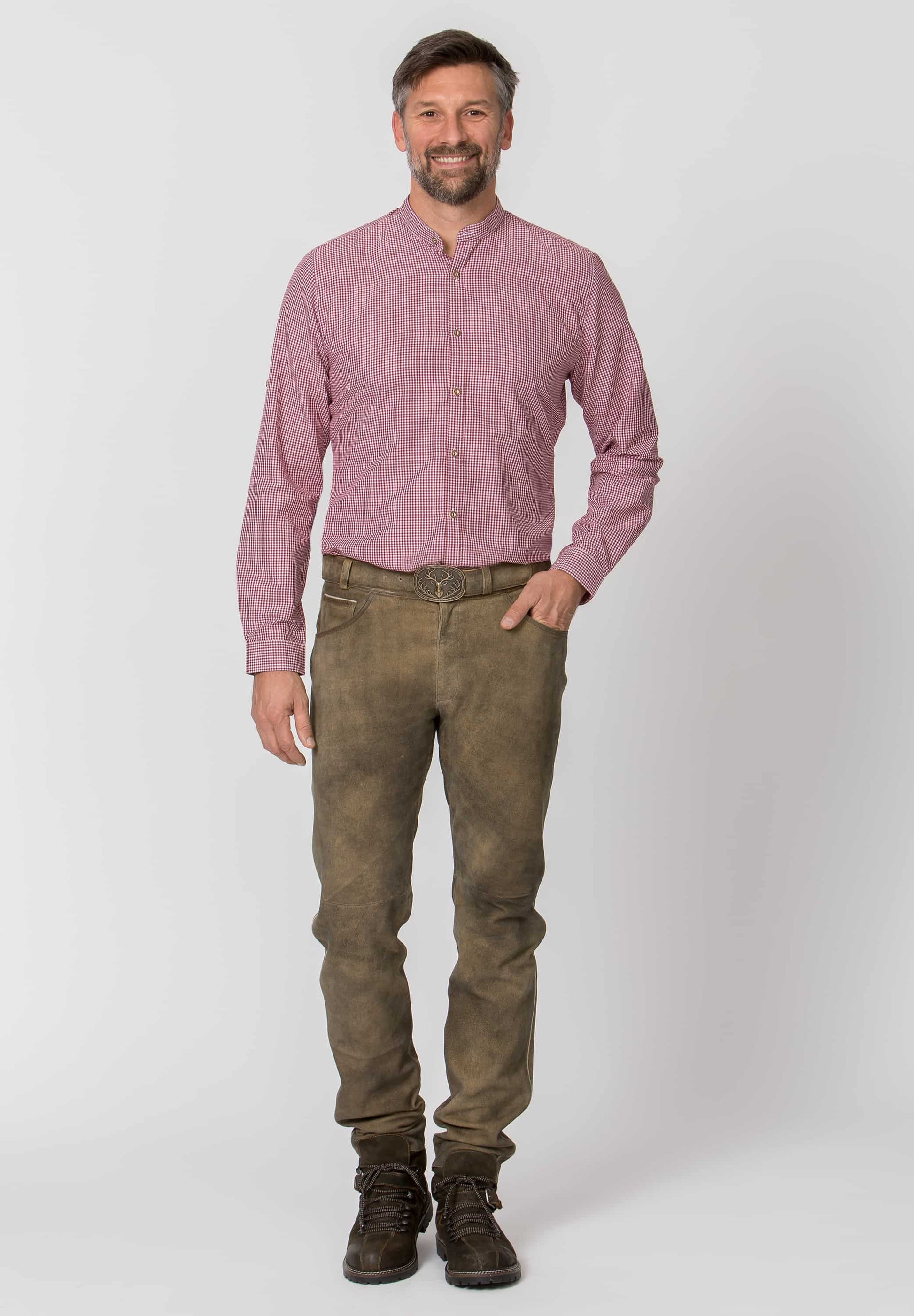 Man wearing a pink shirt and brown pants on a white background