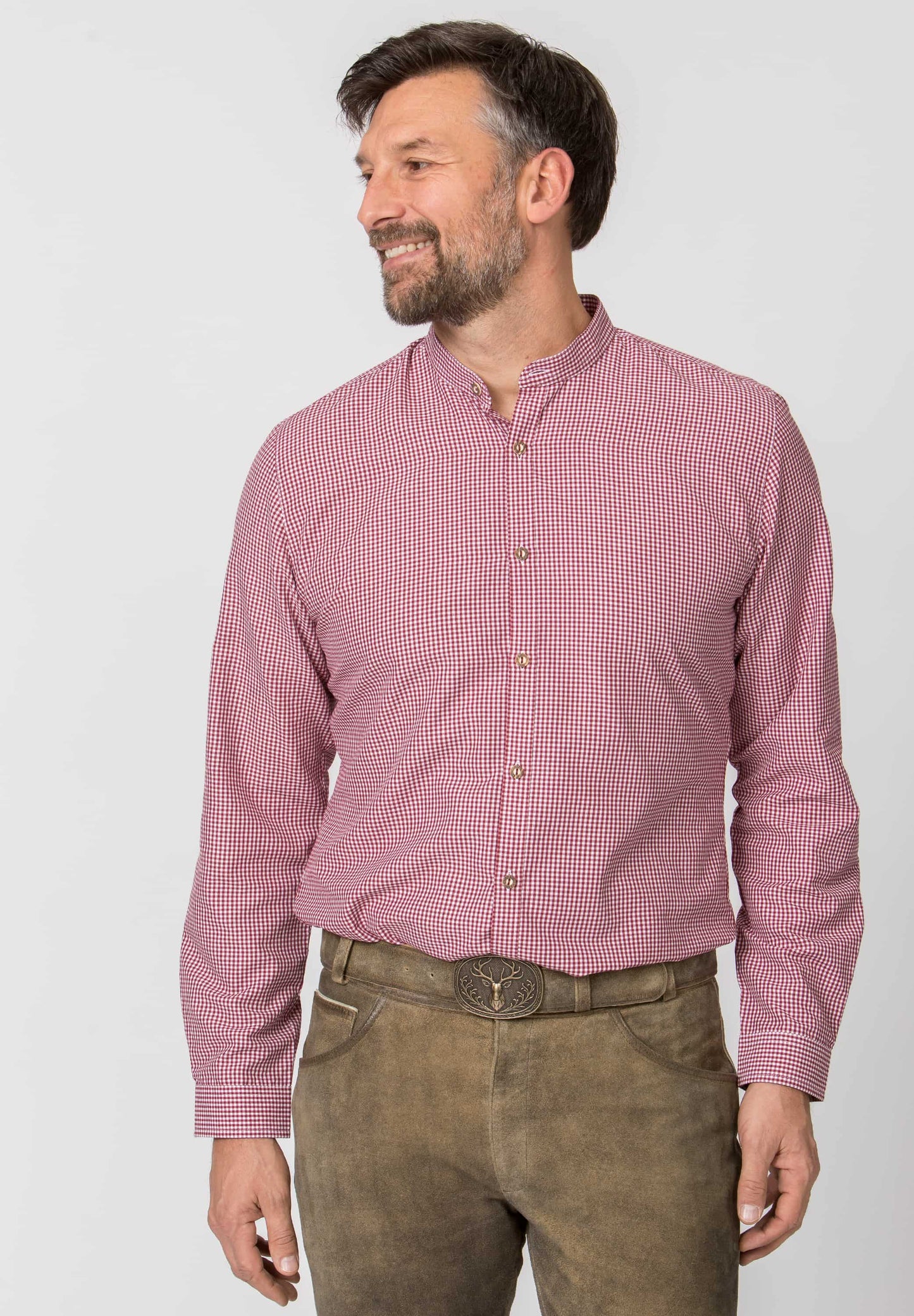 Man wearing a red checkered shirt and brown pants on a white background