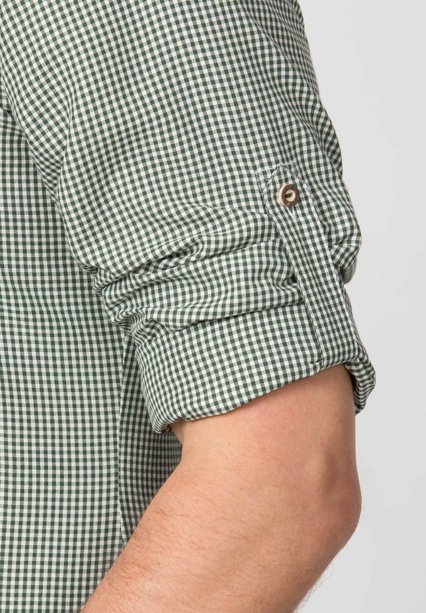 Green and white checkered shirt with rolled-up sleeves on a plain background