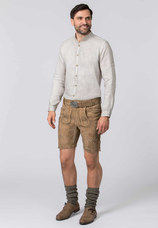 man wearing a Hemp colored men's linen shirt with horn like buttons  with a button tab sleeve  with a pair of lederhosen.