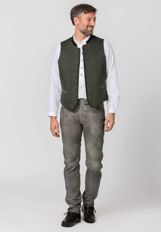Man wearing a green vest over a white shirt with gray leather lederhosen pants on a white background