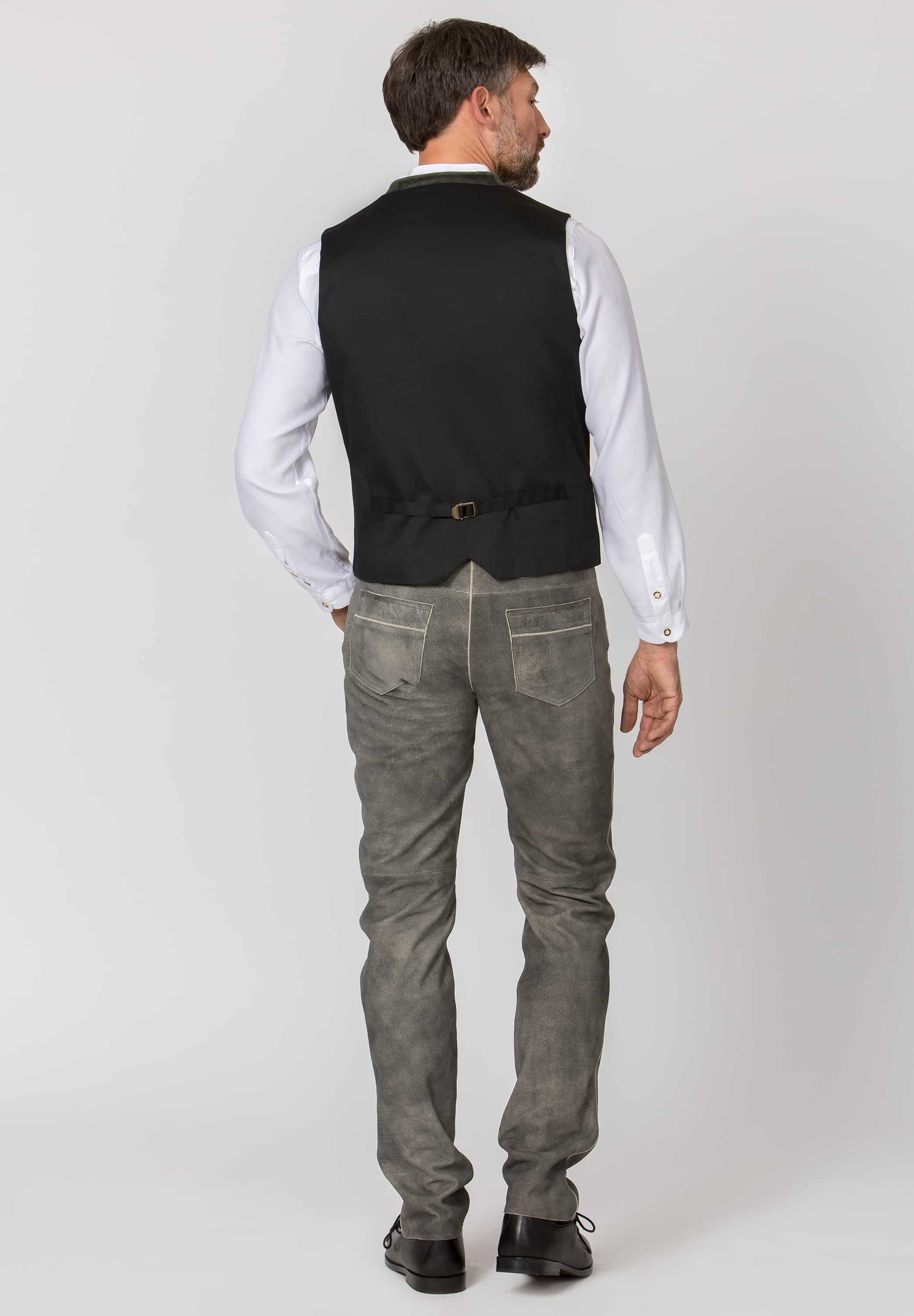 back view Man wearing a green vest over a white shirt with gray leather lederhosen pants on a white background