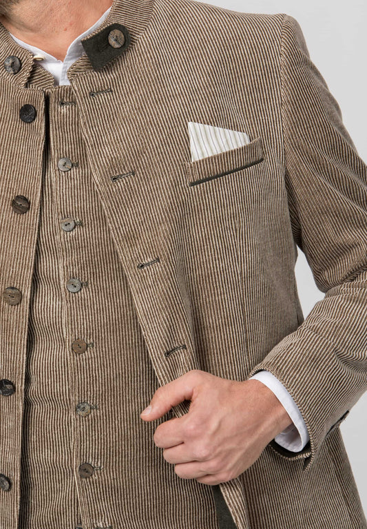 Close-up of a man wearing a brown corduroy jacket over a matching vest, with a white shirt and a striped pocket square visible.