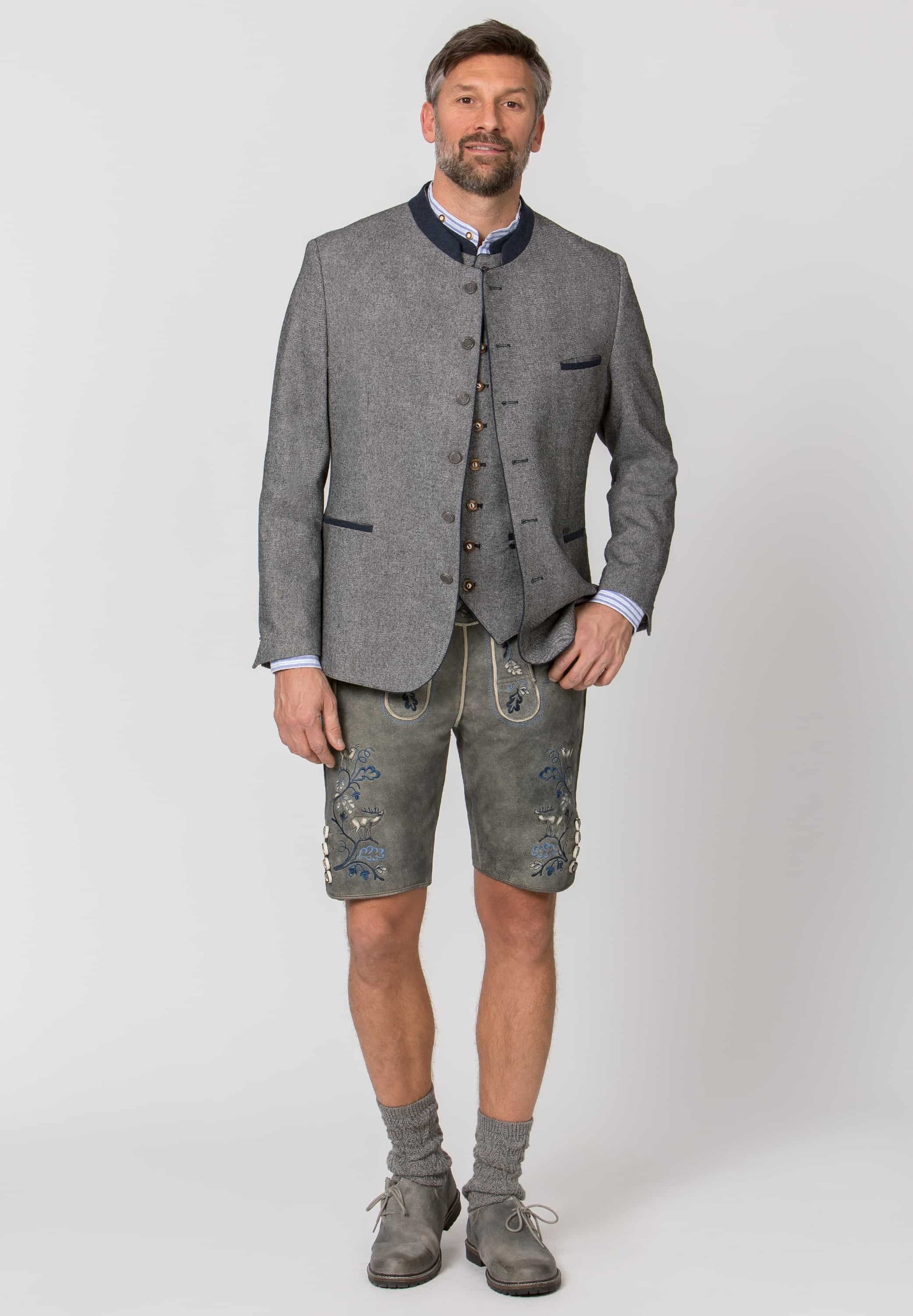 Man wearing a traditional German outfit with a jacket and shorts on a white background