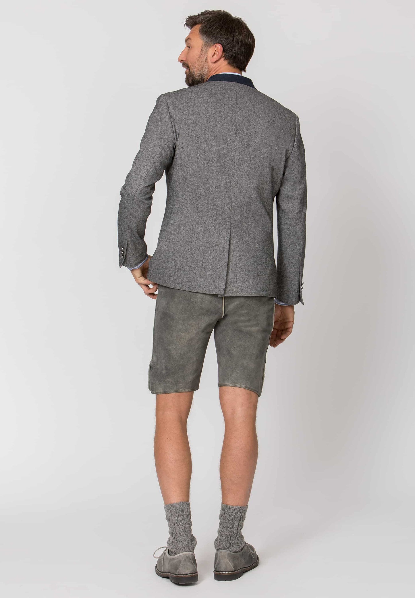 Man wearing a gray suit with shorts on a white background