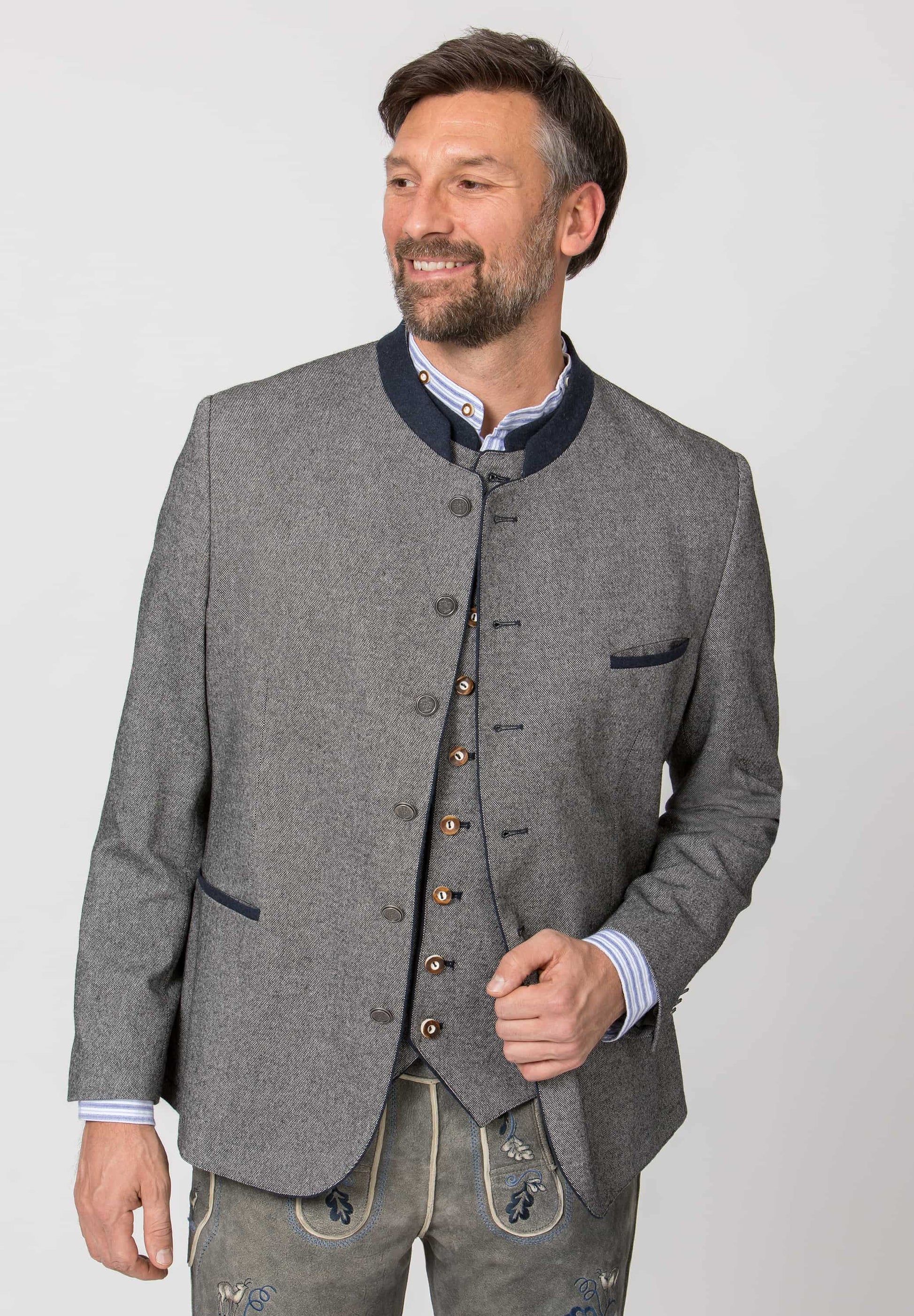 Man wearing a traditional gray jacket with buttons on a plain background