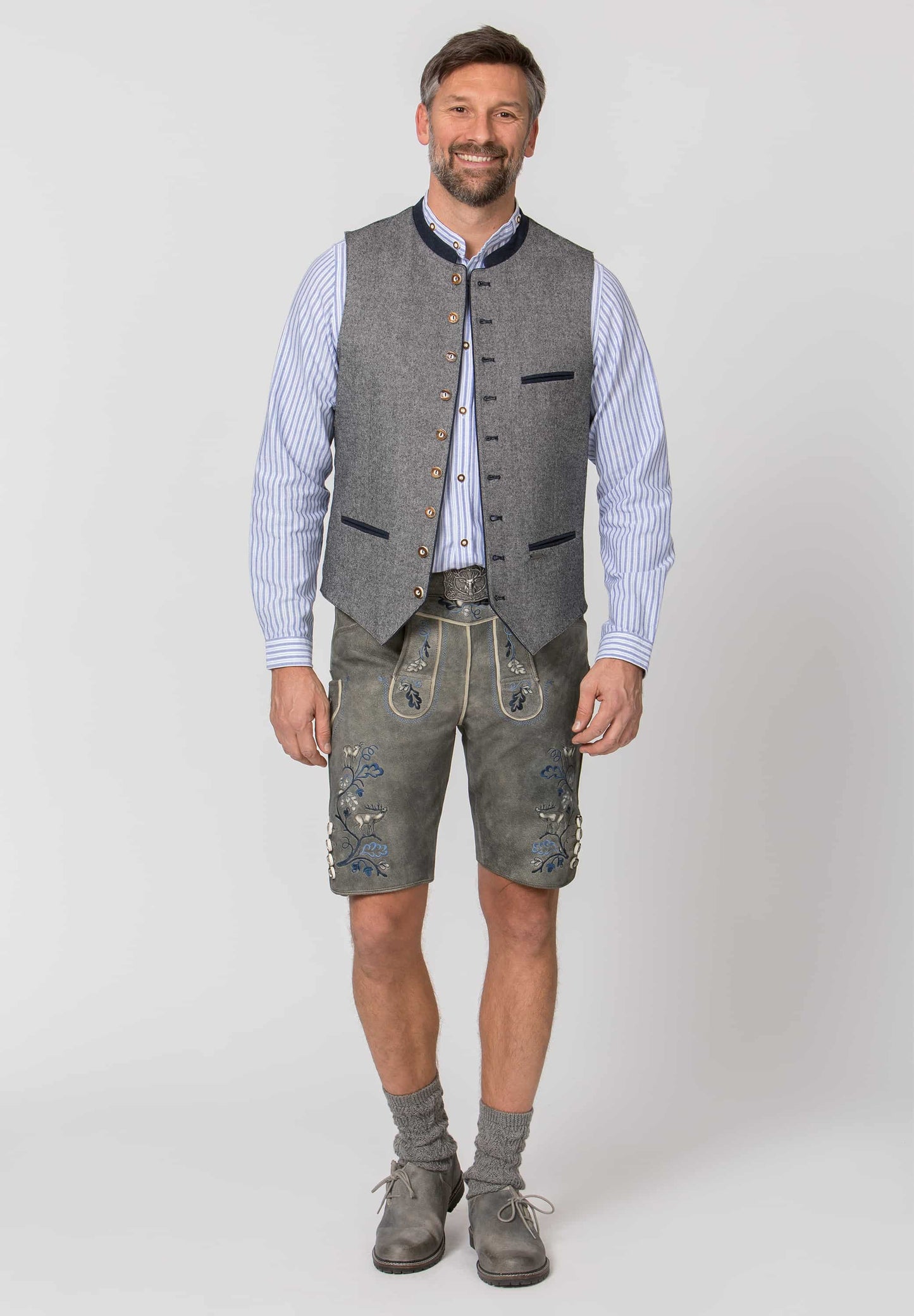 Man wearing traditional German clothing with a gray vest and shorts on a white background