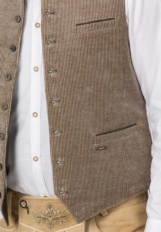 Close-up of a brown corduroy vest worn over a white button-up shirt and tan trousers with embroidered detail.