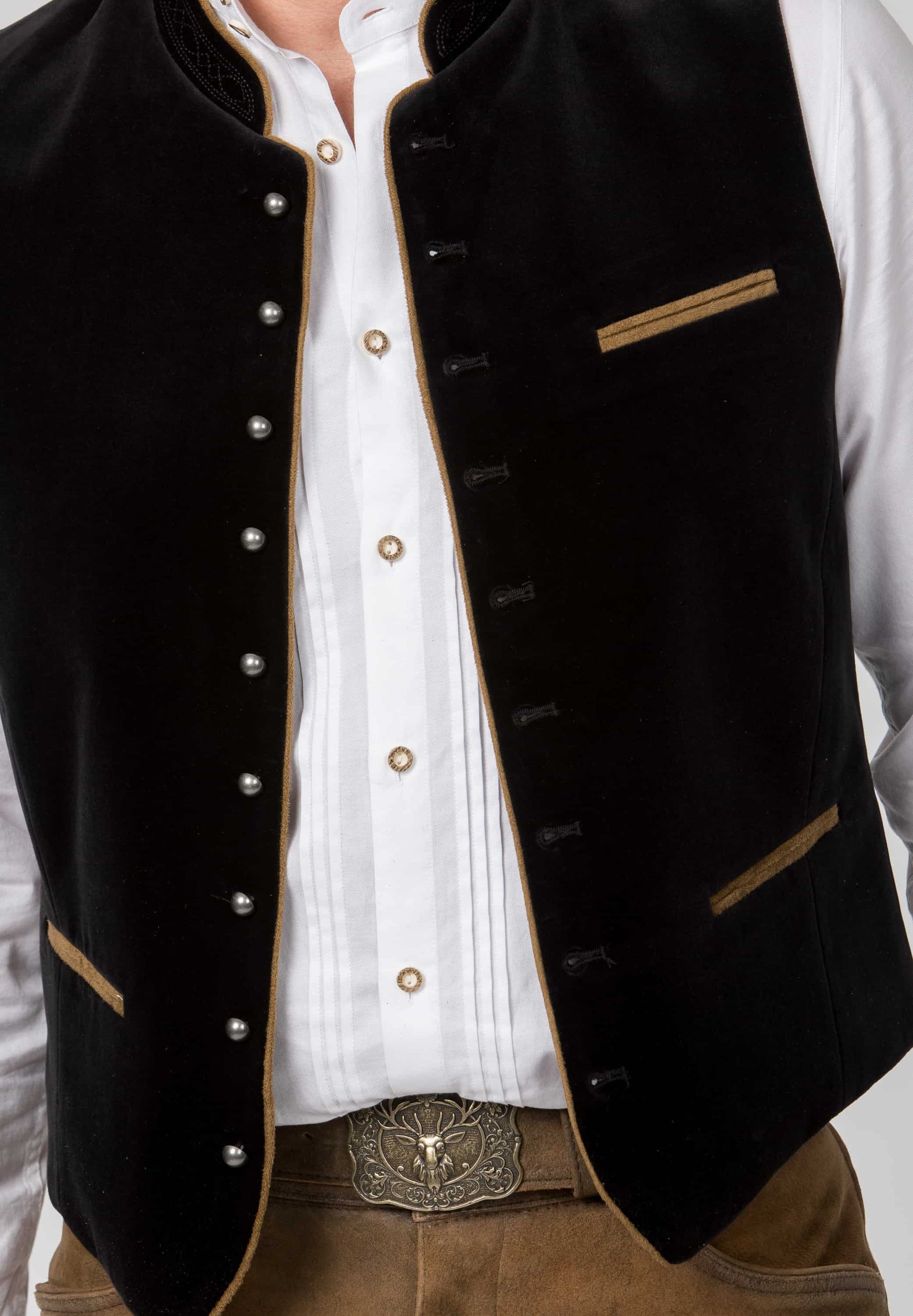 Black vest with gold accents worn over a white shirt on a plain background